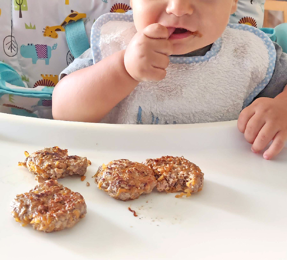 Bebé comiendo las hamburguesas de ternera con calabaza